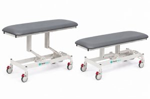 Forme Medical Jasper treatment table in grey, shown raised and lowered