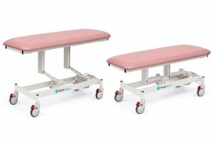 Forme Medical Jasper treatment table in pink, shown raised and lowered